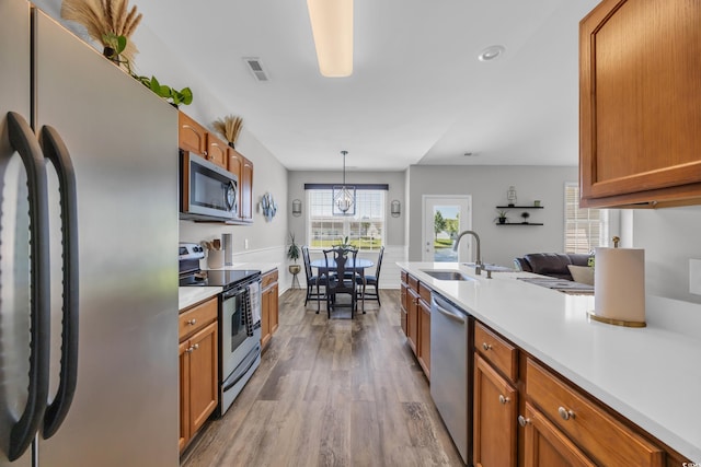 1451 Virginia Pine Dr, Longs, SC 29568 - kitchen with appliances with stainless steel finishes, a sink, wood finished floors, brown cabinets, and light countertops