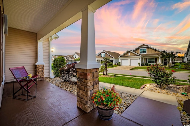 605 Ginger Lily Way, Little River, SC 29566 - patio terrace at dusk featuring a porch and a residential view