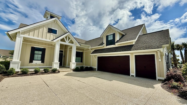 view of front of house featuring board and batten siding, driveway, roof with shingles, and covered porch