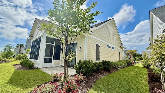 view of side of home featuring a yard and a sunroom