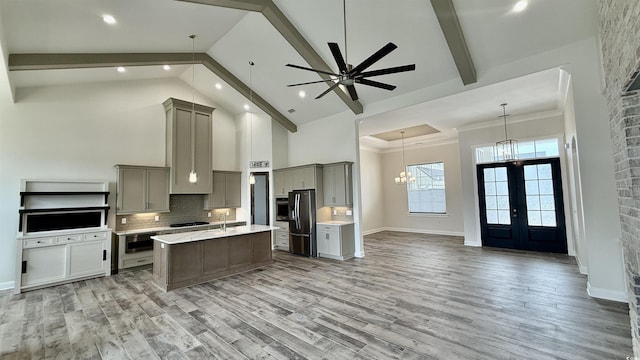 kitchen featuring open floor plan, gray cabinetry, refrigerator with ice dispenser, a chandelier, and beamed ceiling
