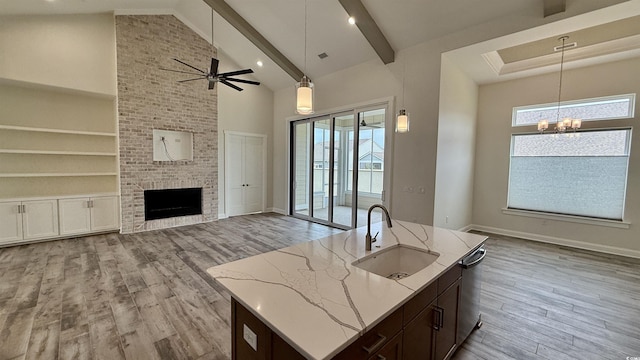 kitchen featuring a sink, open floor plan, plenty of natural light, a chandelier, and high vaulted ceiling