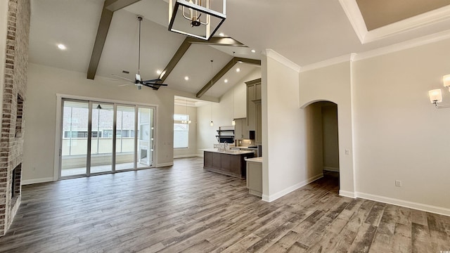 kitchen featuring open floor plan, light countertops, high vaulted ceiling, arched walkways, and ceiling fan