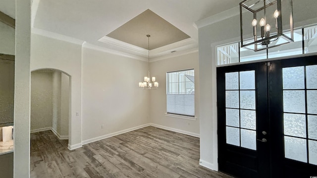 foyer with a chandelier, french doors, arched walkways, crown molding, and baseboards