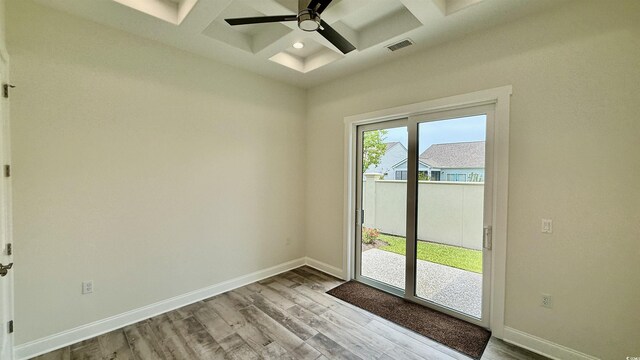 spare room featuring coffered ceiling, wood finished floors, a ceiling fan, baseboards, and beam ceiling