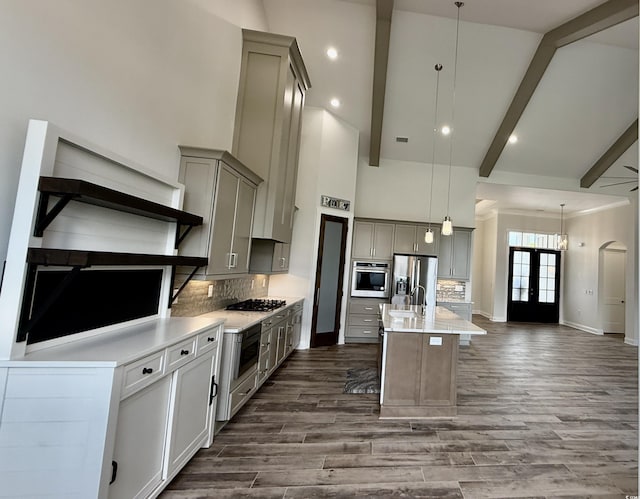 kitchen featuring appliances with stainless steel finishes, gray cabinetry, beamed ceiling, tasteful backsplash, and light countertops