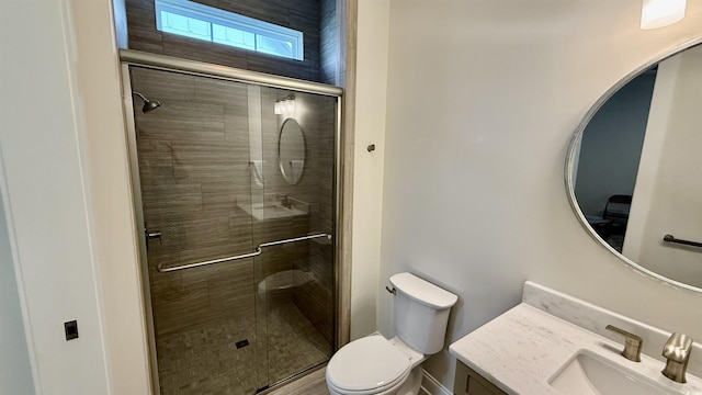 bathroom featuring toilet, a stall shower, and vanity