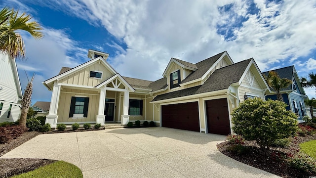 view of front of home featuring board and batten siding, driveway, a porch, and roof with shingles