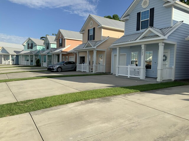 739 Shell Creek Cir Unit 739, North Myrtle Beach, SC 29582 - view of front facade with a porch, concrete driveway, a residential view, and metal roof