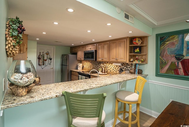 4440 Nassau Ct Unit 308, Little River, SC 29566 - kitchen featuring appliances with stainless steel finishes, light stone counters, wainscoting, open shelves, and tasteful backsplash