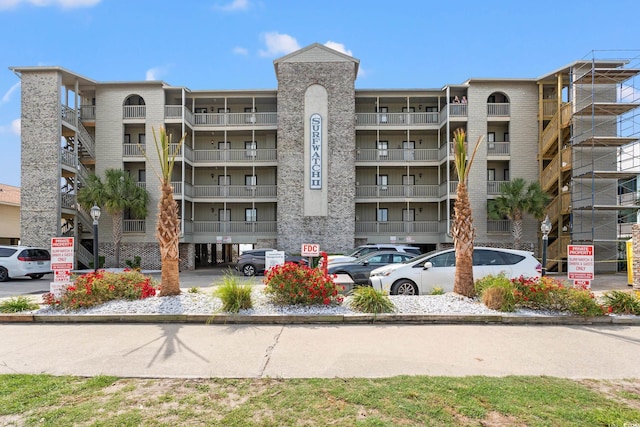 view of apartment building / complex featuring uncovered parking