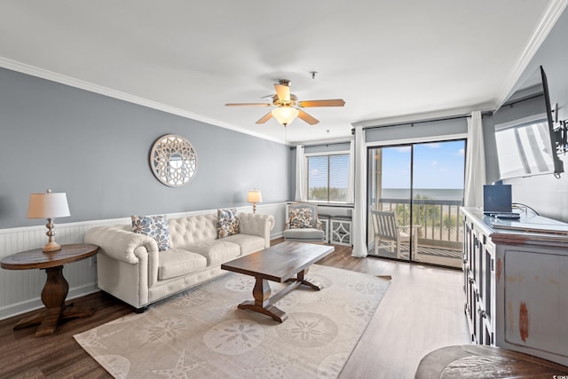 living area with ceiling fan, wood finished floors, and crown molding