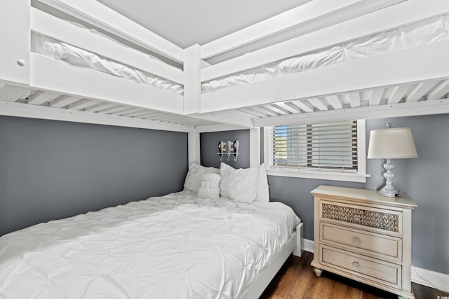 bedroom featuring wood finished floors and baseboards