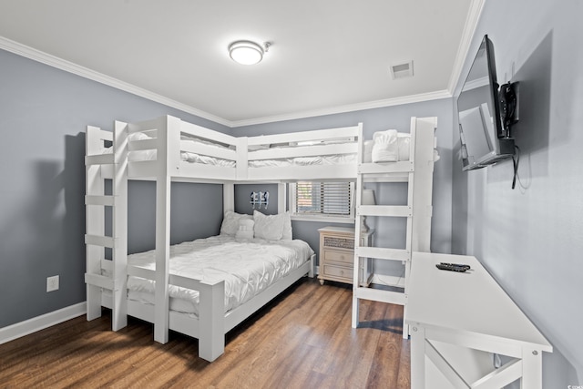 bedroom featuring ornamental molding, wood finished floors, and baseboards