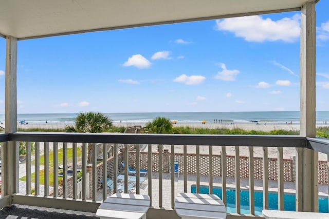 balcony featuring view of water and beach and view of pool area