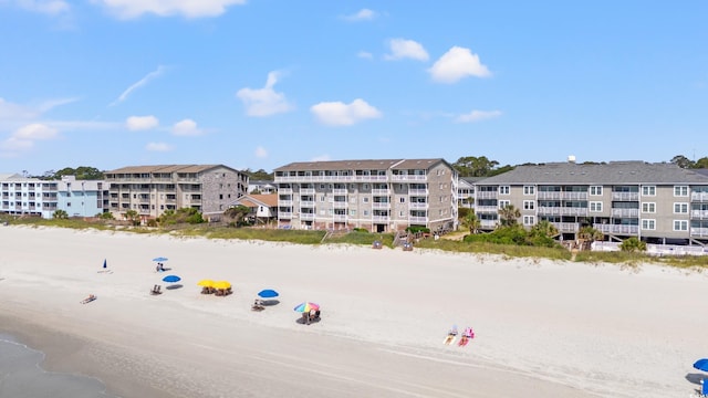 view of apartment building / complex featuring view of water and beach