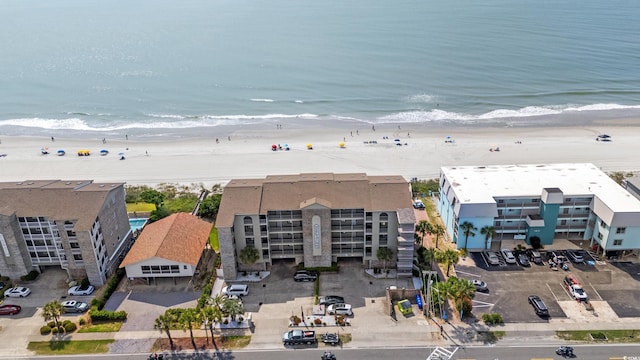aerial view of waterfront with a beach and apartment complex