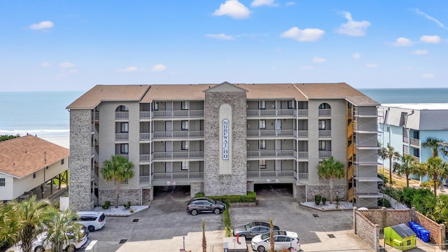 view of apartment building / complex featuring a water view and uncovered parking
