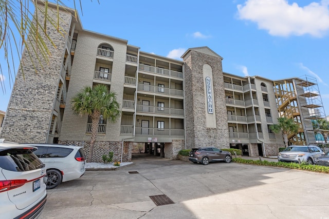 view of apartment building / complex with uncovered parking