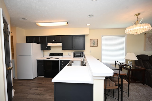 669 Tupelo Ln Unit 18D, Longs, SC 29568 - kitchen with electric stove, freestanding refrigerator, under cabinet range hood, stainless steel microwave, and a breakfast bar area