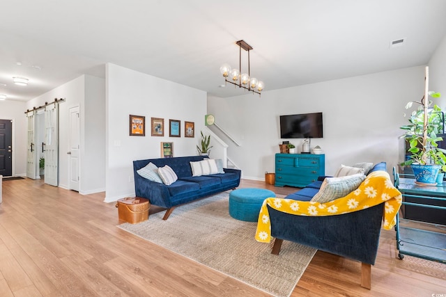 205 Marsh Deer Pl, Surfside Beach, SC 29575 - living room featuring a barn door, stairs, wood finished floors, baseboards, and a chandelier