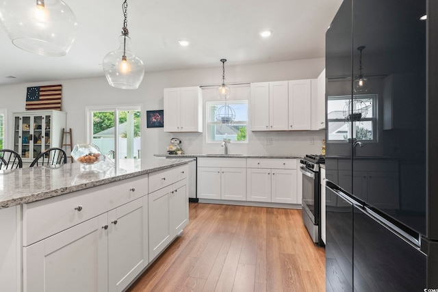 205 Marsh Deer Pl, Surfside Beach, SC 29575 - kitchen featuring a sink, range with gas stovetop, black refrigerator, light wood-type flooring, and backsplash