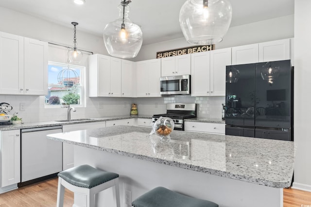 205 Marsh Deer Pl, Surfside Beach, SC 29575 - kitchen featuring stainless steel appliances, a sink, white cabinets, and light wood-style floors