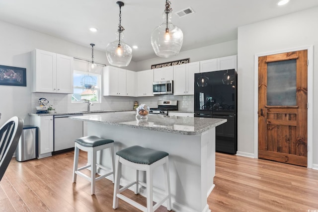 205 Marsh Deer Pl, Surfside Beach, SC 29575 - kitchen featuring stainless steel appliances, light wood-style floors, a breakfast bar, backsplash, and recessed lighting
