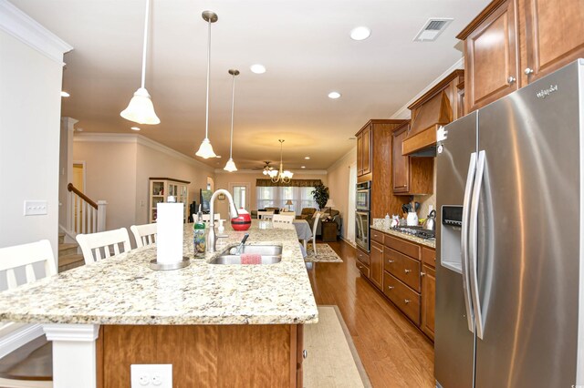 1141 Prescott Cir, Myrtle Beach, SC 29577 - kitchen featuring appliances with stainless steel finishes, a sink, brown cabinets, a kitchen breakfast bar, and ornamental molding