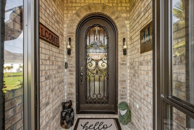 property entrance with brick siding and a porch