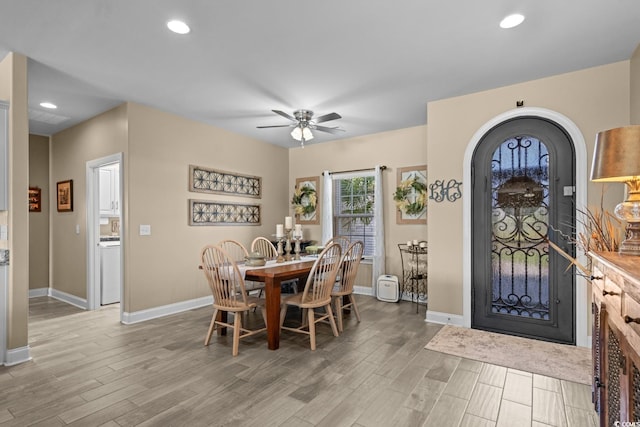 dining area featuring baseboards, light wood-type flooring, ceiling fan, arched walkways, and recessed lighting