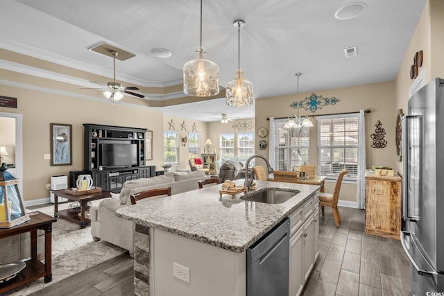 kitchen with a sink, stainless steel appliances, ceiling fan, dark wood finished floors, and plenty of natural light