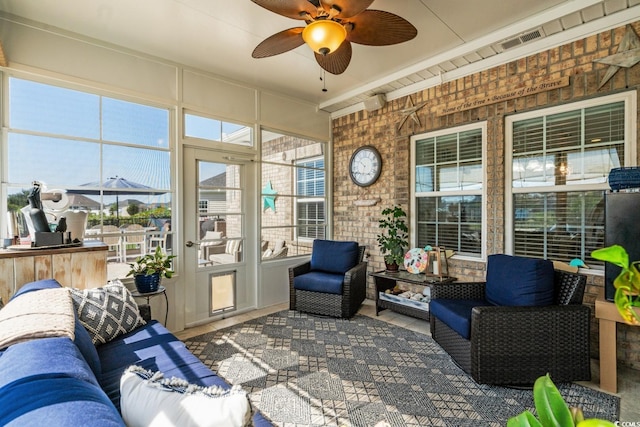 sunroom featuring a ceiling fan, healthy amount of natural light, and an outdoor living space