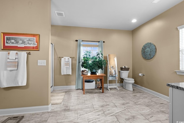 full bathroom featuring toilet, baseboards, a stall shower, and vanity