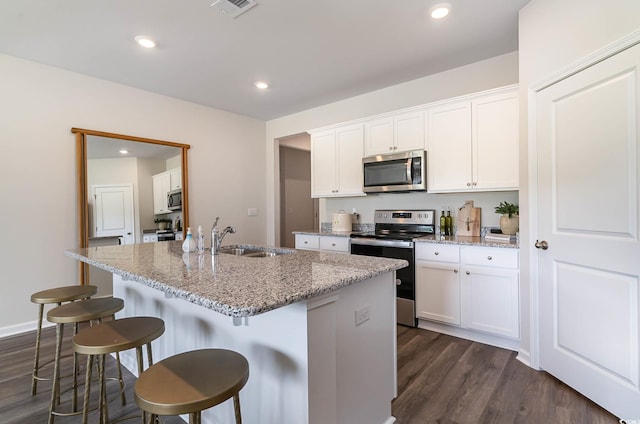 2859 Riverboat Way, Conway, SC 29526 - kitchen with appliances with stainless steel finishes, a sink, dark wood-style floors, a center island with sink, and light stone countertops