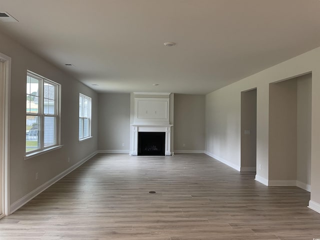 3391 Moss Bridge Ln, Myrtle Beach, SC 29579 - unfurnished living room with a fireplace, light wood-style flooring, and baseboards