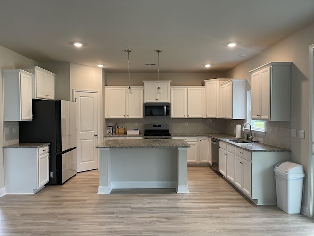 3391 Moss Bridge Ln, Myrtle Beach, SC 29579 - kitchen with stainless steel appliances, a sink, a center island, light wood finished floors, and backsplash