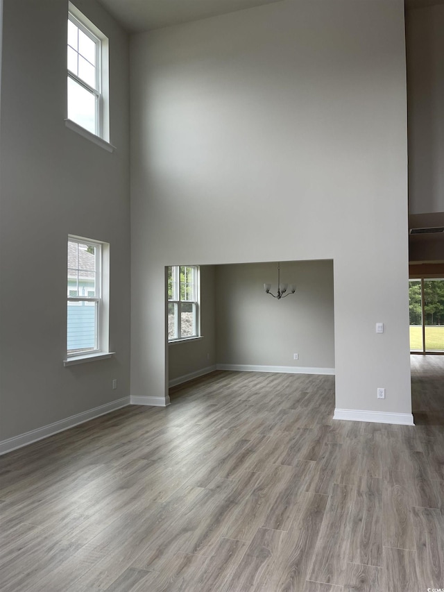 3391 Moss Bridge Ln, Myrtle Beach, SC 29579 - spare room with a high ceiling, a chandelier, wood finished floors, healthy amount of natural light, and baseboards