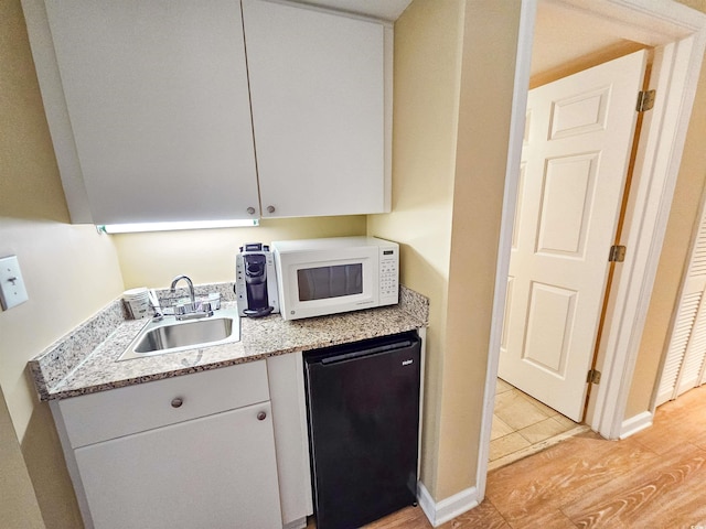 8560 Queensway Blvd Unit 508, Myrtle Beach, SC 29572 - kitchen featuring white microwave, fridge, white cabinetry, and light wood-style flooring