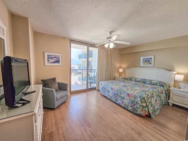 8560 Queensway Blvd Unit 508, Myrtle Beach, SC 29572 - bedroom featuring a textured ceiling, access to exterior, light wood-style flooring, ceiling fan, and expansive windows