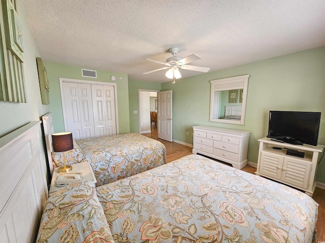 8560 Queensway Blvd Unit 508, Myrtle Beach, SC 29572 - bedroom featuring a closet, ceiling fan, a textured ceiling, and wood finished floors