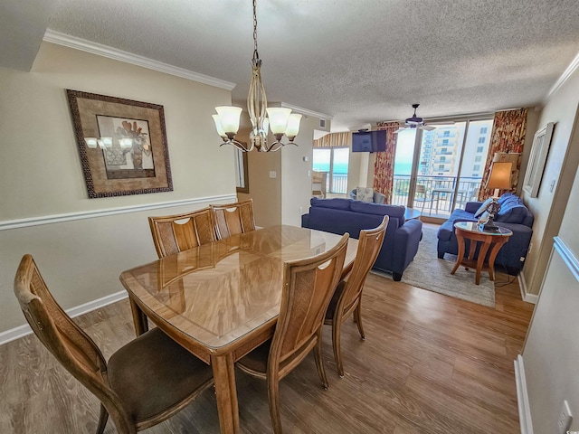 8560 Queensway Blvd Unit 508, Myrtle Beach, SC 29572 - dining area featuring light wood-style floors, a textured ceiling, a chandelier, and ornamental molding