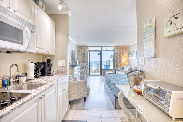 201 74th Ave N Unit 2241, Myrtle Beach, SC 29572 - kitchen featuring a textured wall, white microwave, a sink, crown molding, and black electric stovetop