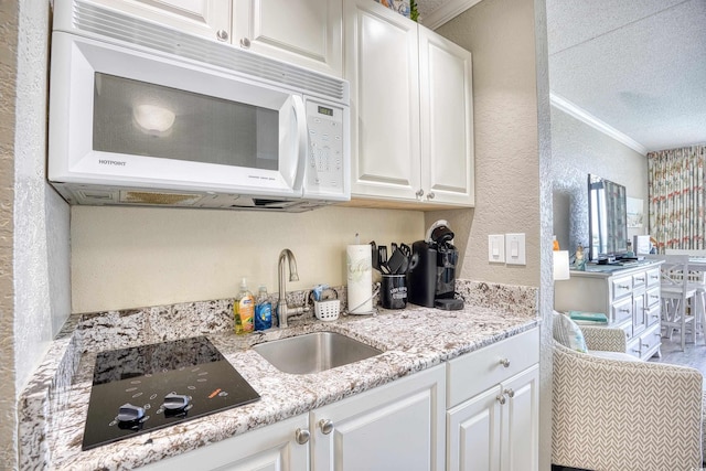 201 74th Ave N Unit 2241, Myrtle Beach, SC 29572 - kitchen featuring white microwave, a sink, a textured wall, black electric stovetop, and crown molding