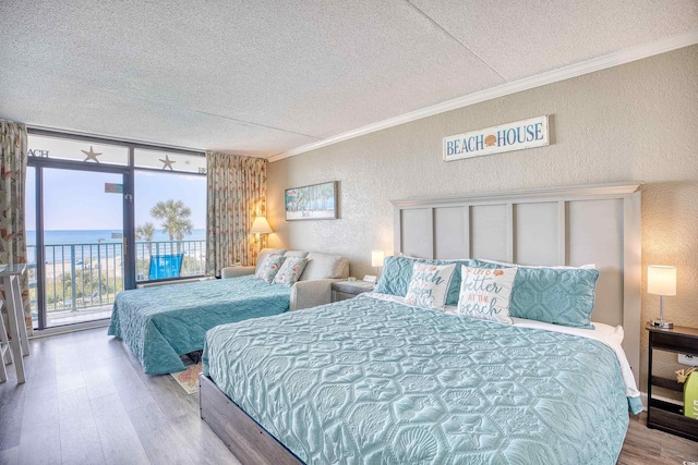 201 74th Ave N Unit 2241, Myrtle Beach, SC 29572 - bedroom with a textured wall, a textured ceiling, wood finished floors, ornamental molding, and access to outside