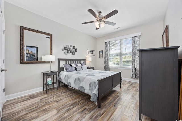 bedroom with baseboards, wood finished floors, and a ceiling fan