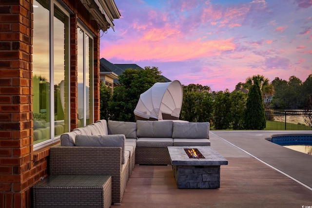patio terrace at dusk featuring an outdoor living space with a fire pit and a patio area