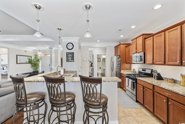kitchen featuring stainless steel appliances, a breakfast bar, ornamental molding, a sink, and open floor plan