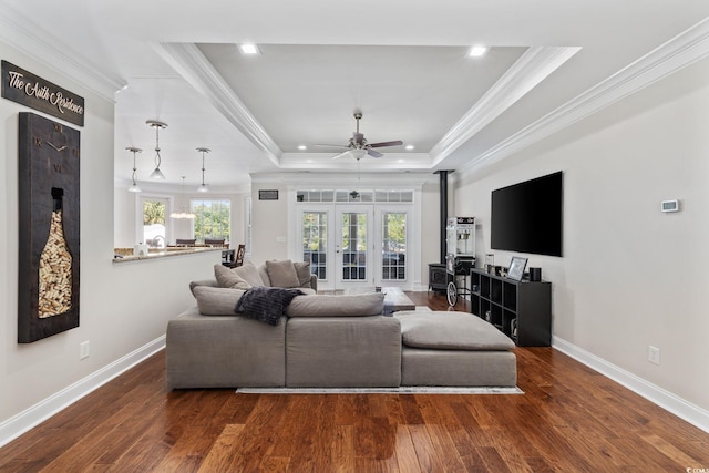 living area featuring crown molding, french doors, ceiling fan, a tray ceiling, and wood finished floors