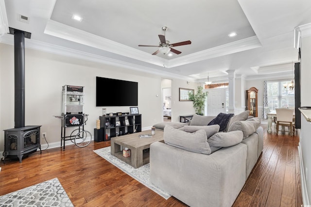 living area featuring a raised ceiling, ceiling fan, crown molding, ornate columns, and wood-type flooring